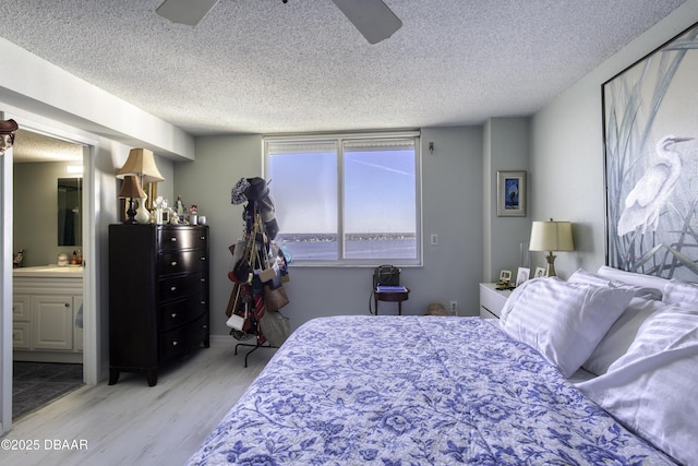 bedroom with ensuite bath, sink, ceiling fan, a textured ceiling, and light wood-type flooring