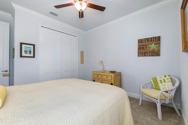 bedroom with ornamental molding, carpet flooring, ceiling fan, and a closet