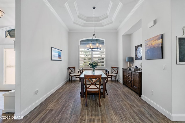 dining space with an inviting chandelier, ornamental molding, dark hardwood / wood-style floors, and a raised ceiling