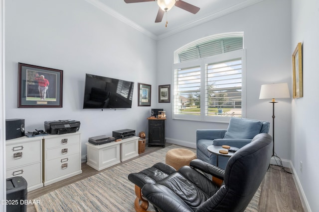 living room featuring ceiling fan, ornamental molding, and light wood-type flooring