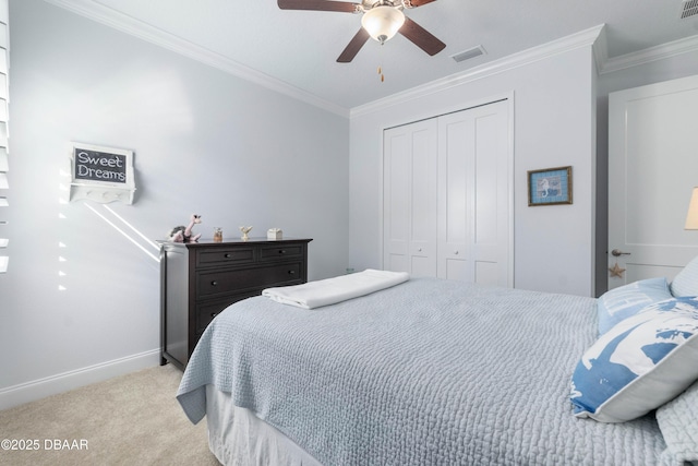 carpeted bedroom with crown molding, ceiling fan, and a closet