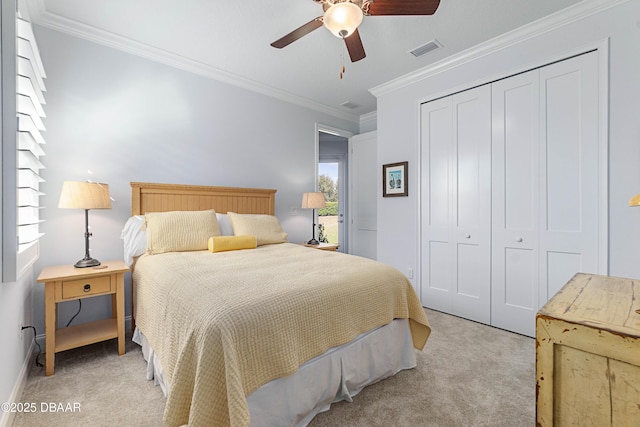 carpeted bedroom featuring ornamental molding, a closet, and ceiling fan