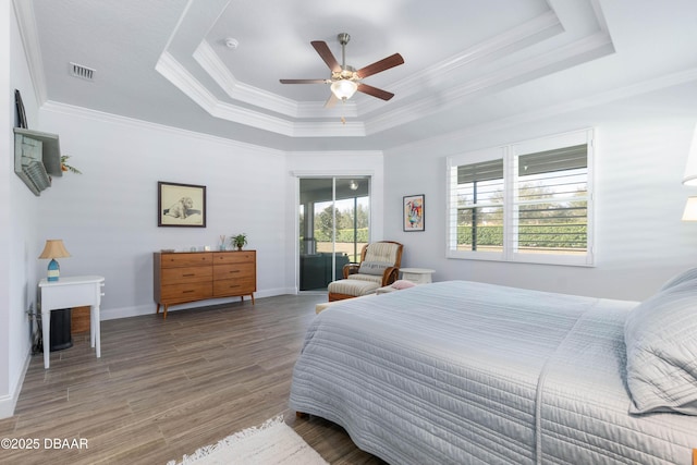 bedroom with crown molding, a raised ceiling, ceiling fan, access to exterior, and hardwood / wood-style floors