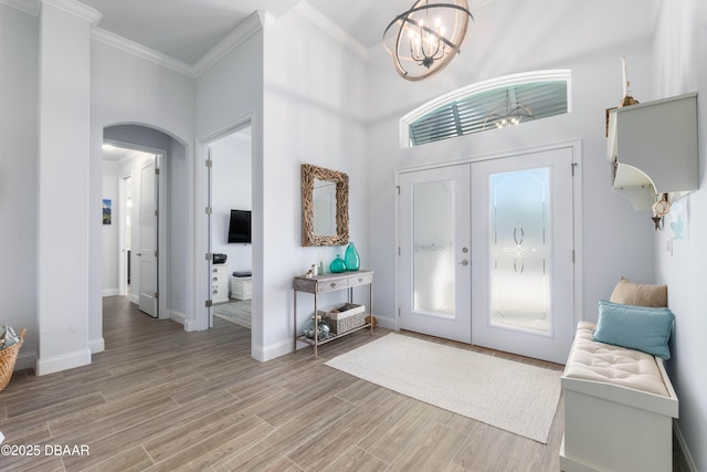 entryway featuring french doors, crown molding, a chandelier, and hardwood / wood-style floors