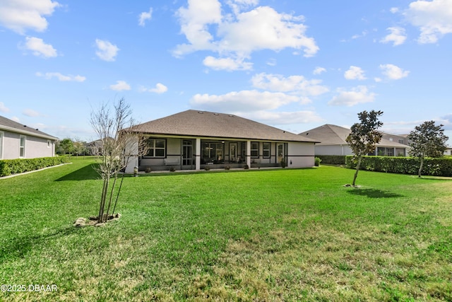 back of house with a sunroom and a lawn