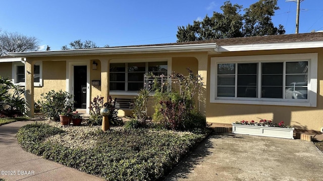 ranch-style home featuring stucco siding