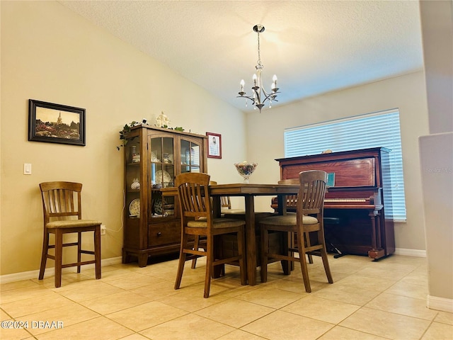 dining space with a chandelier, a textured ceiling, light tile patterned floors, and a healthy amount of sunlight