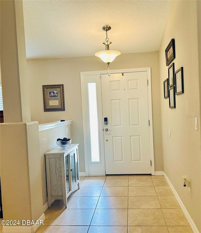 tiled entrance foyer featuring a textured ceiling