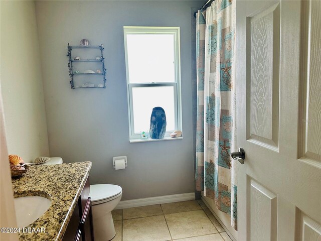 bathroom with vanity, tile patterned flooring, a healthy amount of sunlight, and toilet