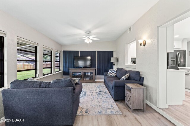 1317 Dexter Dr W, Port Orange, FL 32129 - living area with light wood finished floors, a ceiling fan, baseboards, and vaulted ceiling