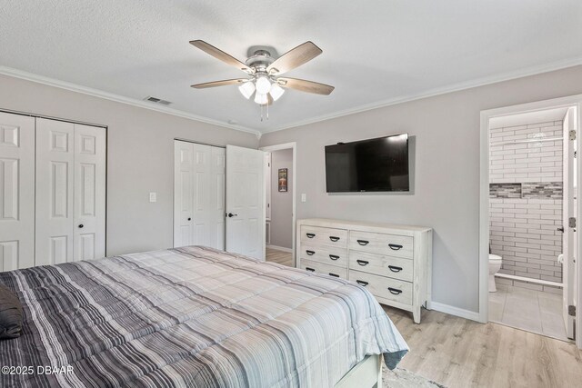 1317 Dexter Dr W, Port Orange, FL 32129 - bedroom with two closets, crown molding, light wood-style floors, ensuite bathroom, and baseboards