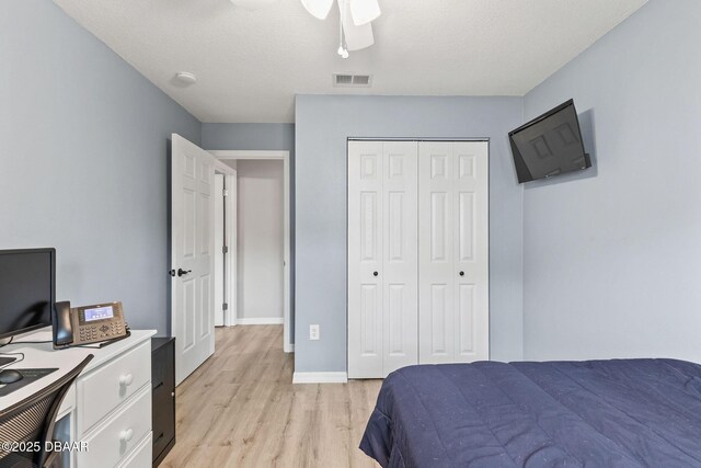 1317 Dexter Dr W, Port Orange, FL 32129 - bedroom featuring light wood-style floors, a closet, ceiling fan, baseboards, and a textured ceiling