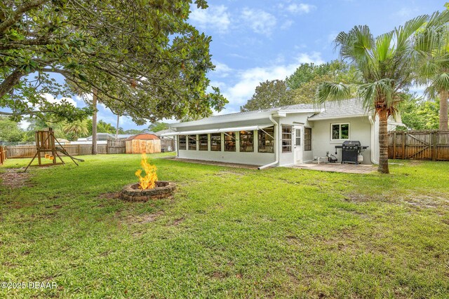1317 Dexter Dr W, Port Orange, FL 32129 - back of house with a fire pit, a patio, stucco siding, and a sunroom