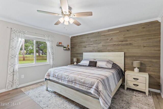 1317 Dexter Dr W, Port Orange, FL 32129 - bedroom featuring crown molding, wooden walls, wood finished floors, baseboards, and ceiling fan