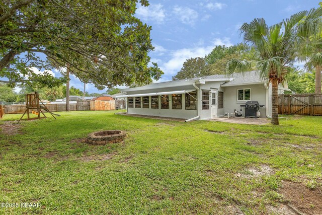 1317 Dexter Dr W, Port Orange, FL 32129 - back of house with a fire pit, a patio area, stucco siding, and a sunroom