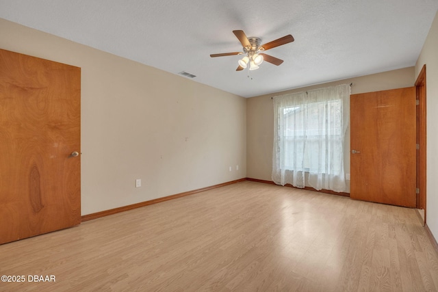 empty room featuring ceiling fan, a textured ceiling, and light hardwood / wood-style flooring