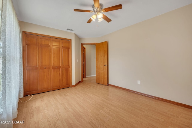 unfurnished bedroom with light hardwood / wood-style flooring, a closet, and ceiling fan