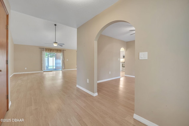 spare room with ceiling fan, light hardwood / wood-style floors, and vaulted ceiling