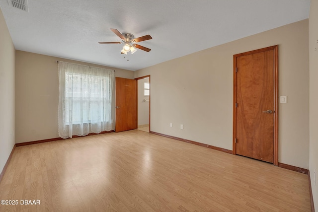 unfurnished room with ceiling fan, a textured ceiling, and light hardwood / wood-style flooring