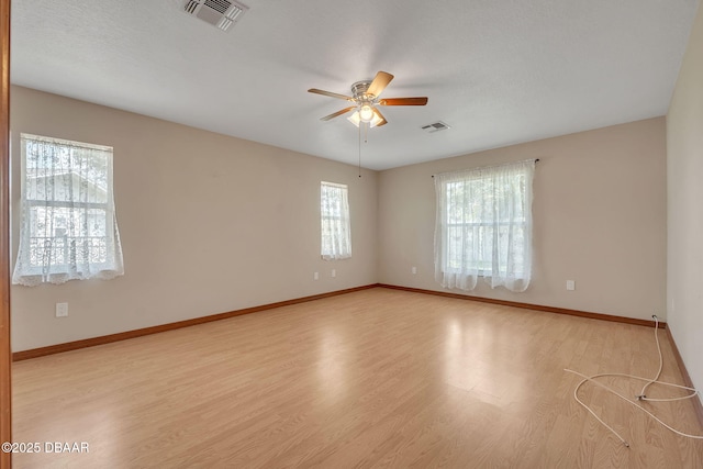 unfurnished room featuring light hardwood / wood-style flooring, a wealth of natural light, and ceiling fan