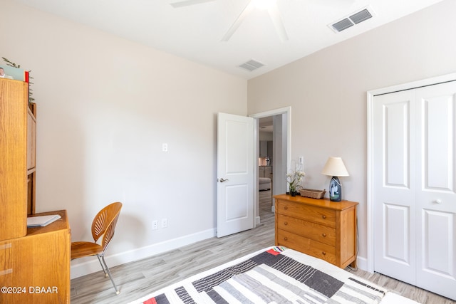 bedroom with a closet, light hardwood / wood-style floors, and ceiling fan