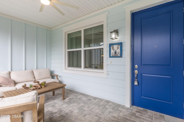 doorway to property featuring a porch, ceiling fan, and an outdoor hangout area