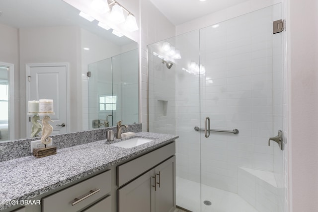 bathroom featuring walk in shower and vanity