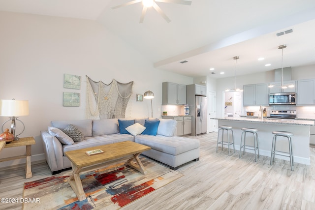 living room with ceiling fan, sink, light hardwood / wood-style flooring, and lofted ceiling