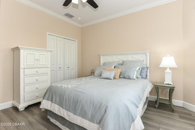bedroom with visible vents, baseboards, crown molding, and wood finished floors