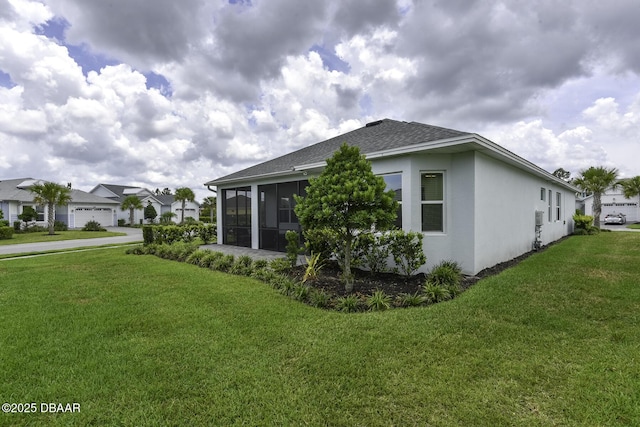 view of side of property with a lawn, a sunroom, roof with shingles, and stucco siding