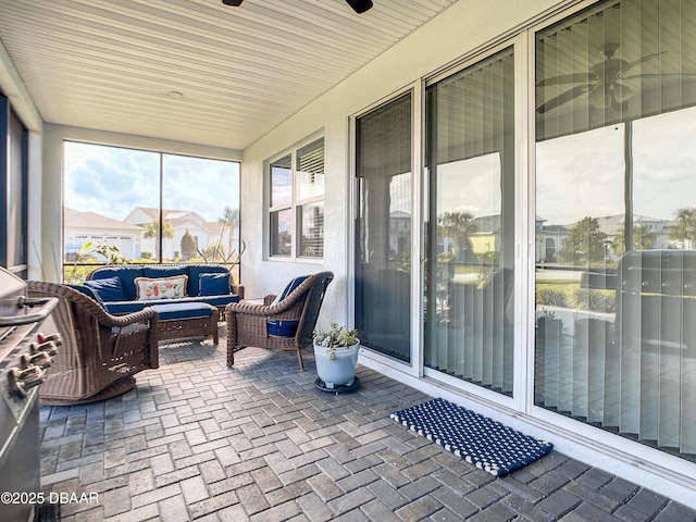 sunroom / solarium featuring ceiling fan and an outdoor hangout area