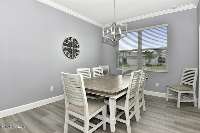dining area with baseboards, a notable chandelier, ornamental molding, and light wood finished floors
