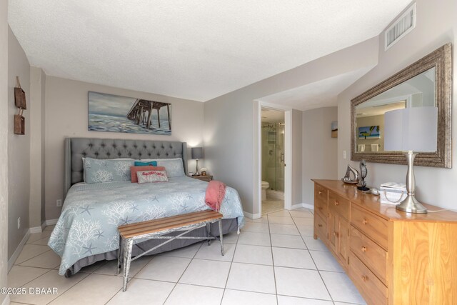 tiled bedroom featuring ensuite bathroom and a textured ceiling