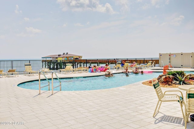 view of pool featuring a patio and a water view