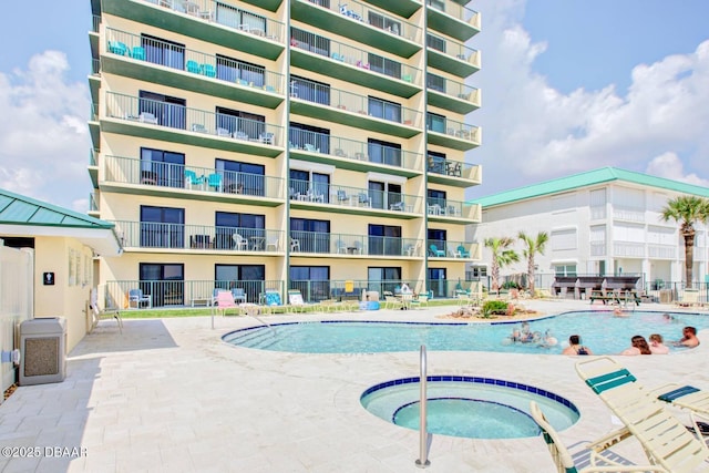 view of swimming pool with a community hot tub and a patio