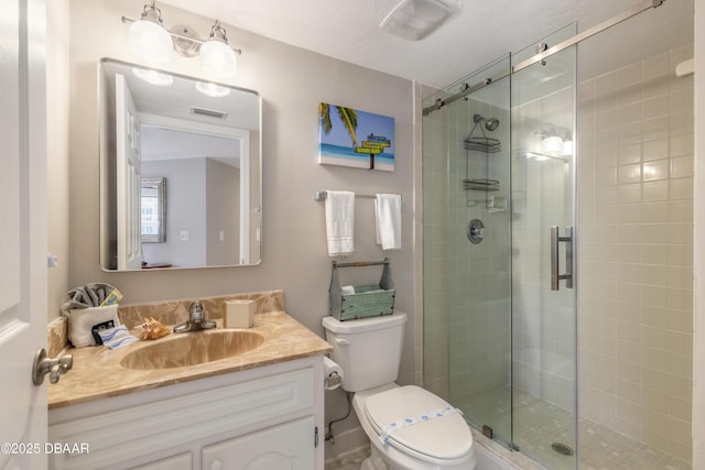 bathroom featuring vanity, an enclosed shower, and toilet