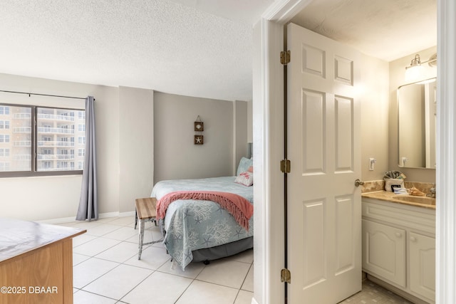 tiled bedroom with sink and a textured ceiling