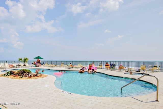 view of pool with a water view and a patio