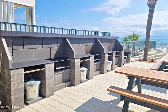 view of patio with a water view and grilling area