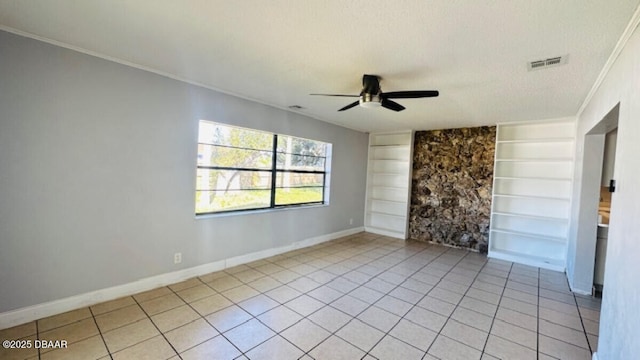 empty room featuring built in features, visible vents, baseboards, and a ceiling fan