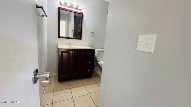 bathroom with toilet, vanity, and tile patterned flooring