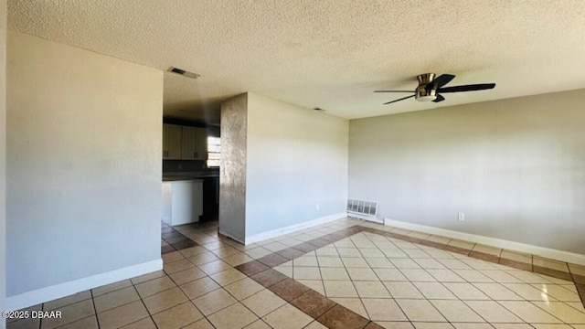 spare room featuring tile patterned floors, visible vents, baseboards, and ceiling fan