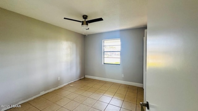 empty room featuring light tile patterned flooring, baseboards, and ceiling fan