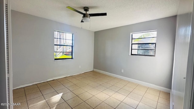 unfurnished room with a textured ceiling, tile patterned floors, a ceiling fan, and a healthy amount of sunlight