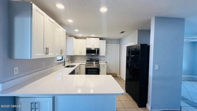 kitchen with light countertops, light tile patterned floors, stainless steel appliances, a textured ceiling, and a sink