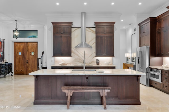 kitchen featuring ornamental molding, appliances with stainless steel finishes, a breakfast bar area, and a center island with sink