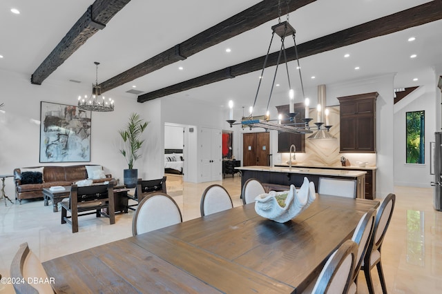 dining room featuring an inviting chandelier, sink, and beamed ceiling