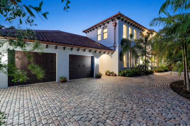 mediterranean / spanish-style house with a garage