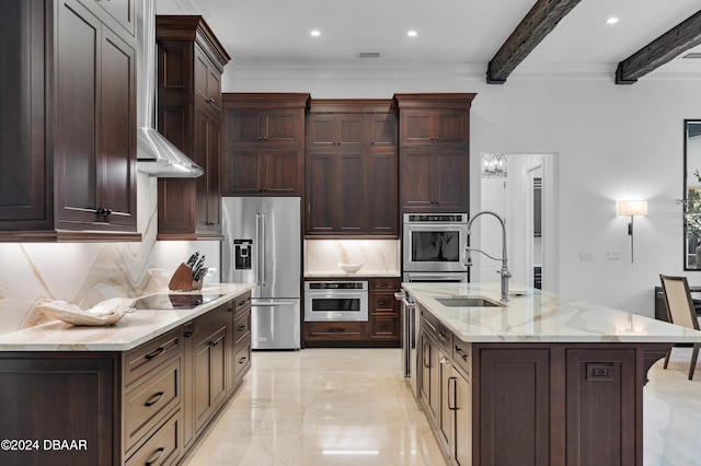 kitchen with beam ceiling, decorative backsplash, a center island with sink, and appliances with stainless steel finishes