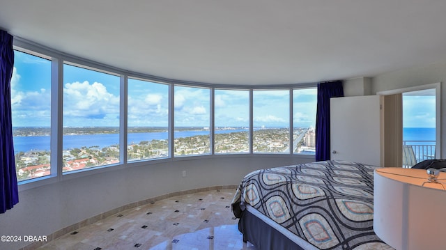 unfurnished bedroom featuring a water view and multiple windows